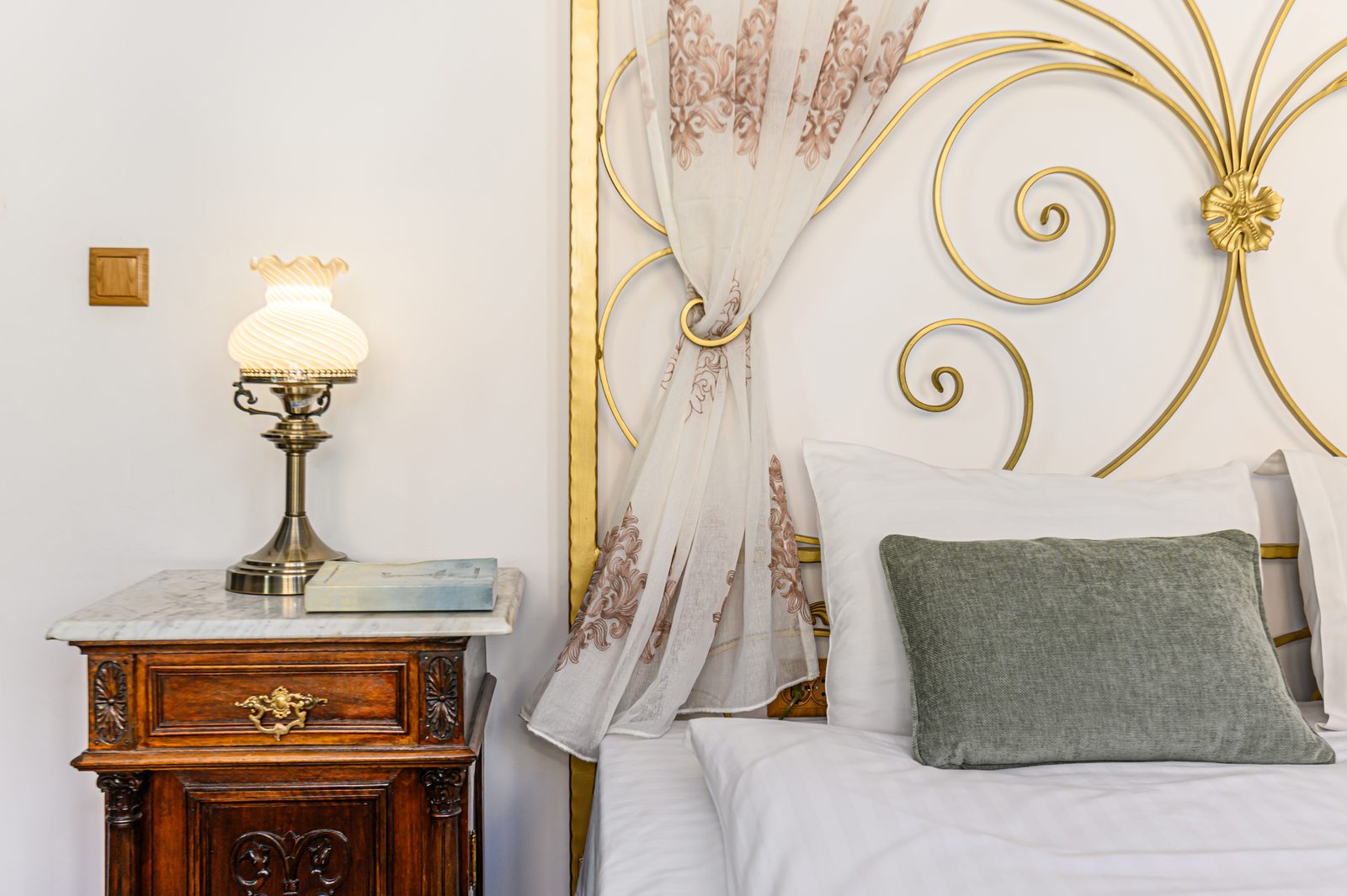 Antique nightstand and gilded headboard detail