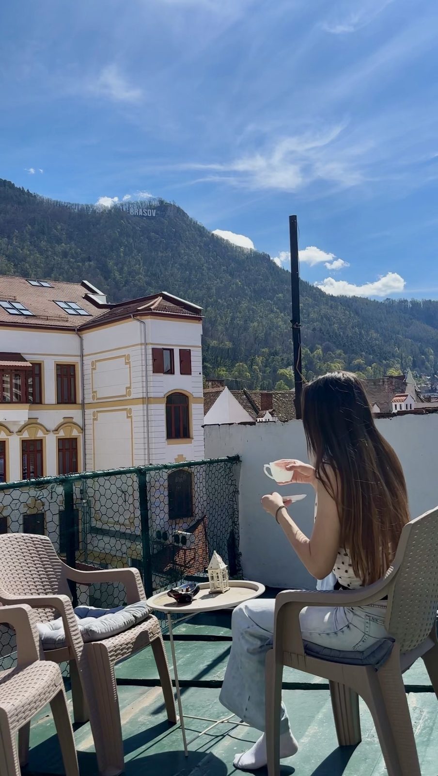 Linda having coffee on her Airbnb rooftop terrace in Brașov